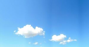 Hot weather forecast with bright blue skies and gentle clouds over a tranquil landscape.