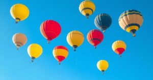 Weather balloons ascending in a clear blue sky, representing meteorological data collection during hurricane season.