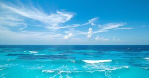A vast ocean scene with soft waves and a clear sky, indicative of potential tropical activity in the Gulf.